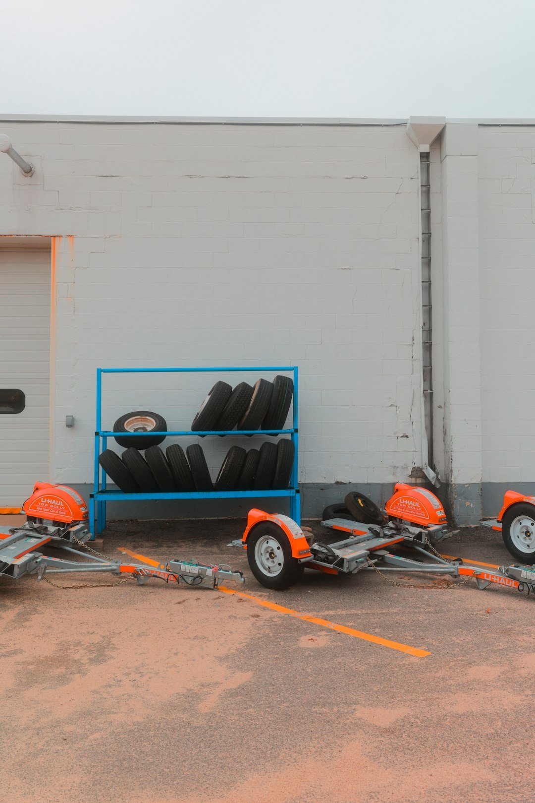 tires-sit-next-to-trailers-in-front-of-a-building-mrvxtyyv5f4